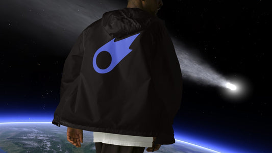 A person wearing a Stellarwear 3I/Atlas windbreaker standing in front of an image of earth and a flying comet