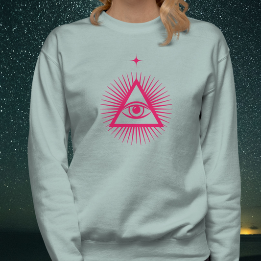 Light blue Stellarwear sweatshirt with pink triangle eye design against a starry night sky background
