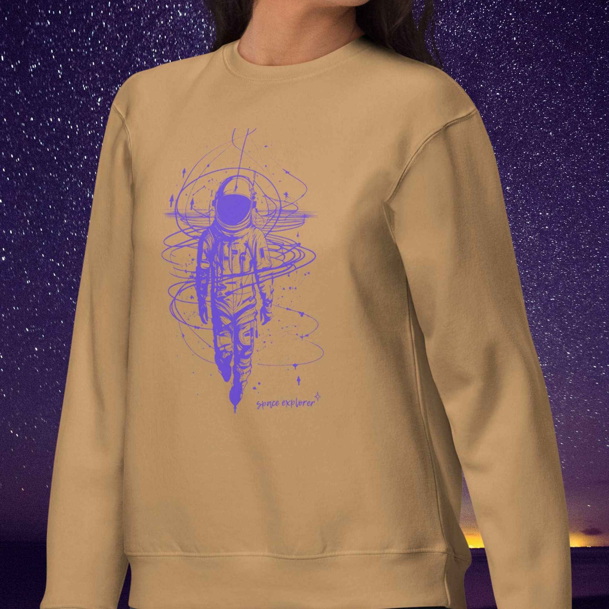 Beige Stellarwear sweatshirt with purple astronaut graphic design against a starry night sky background