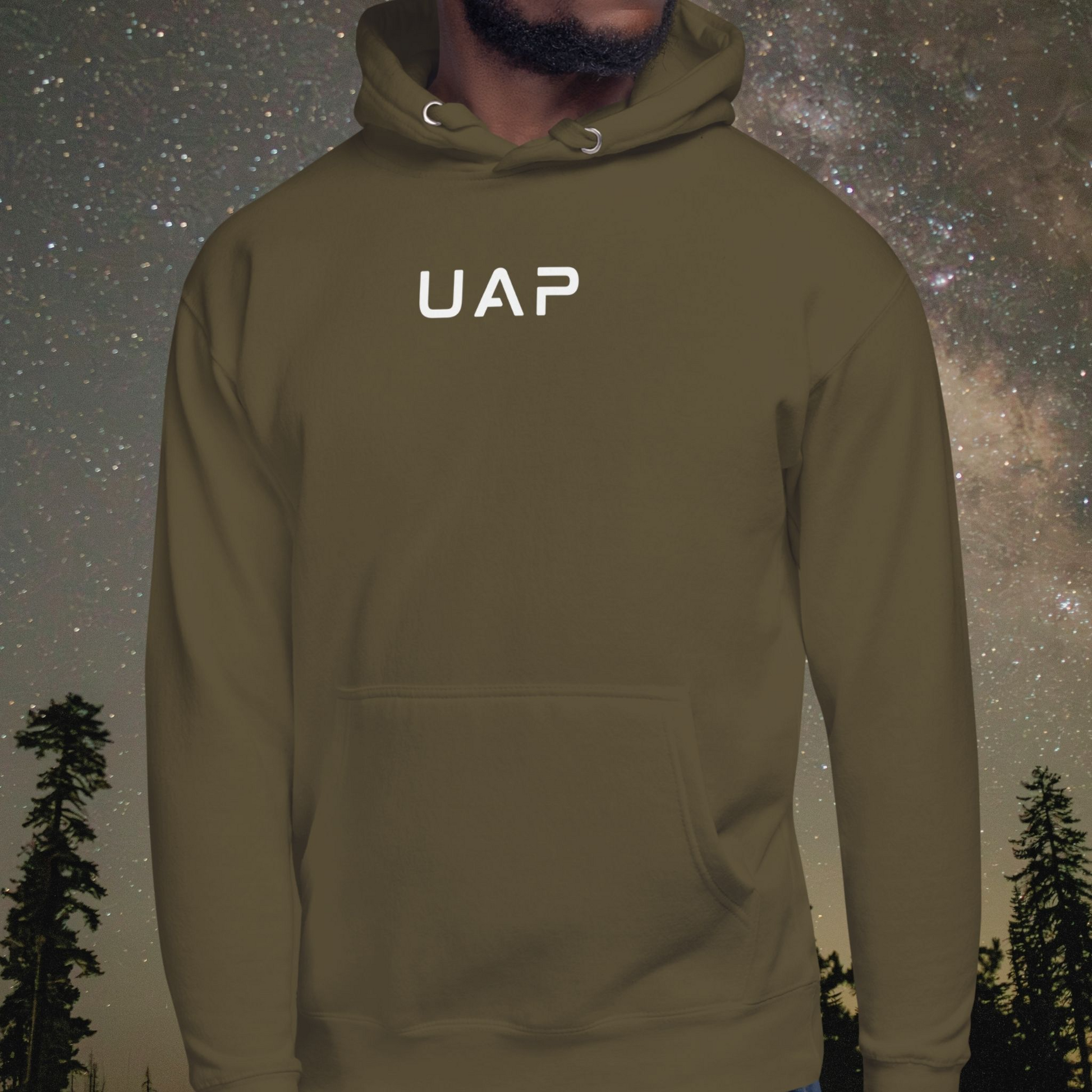 Person wearing a green Stellarwear hoodie with 'UAP' text against a starry night sky background