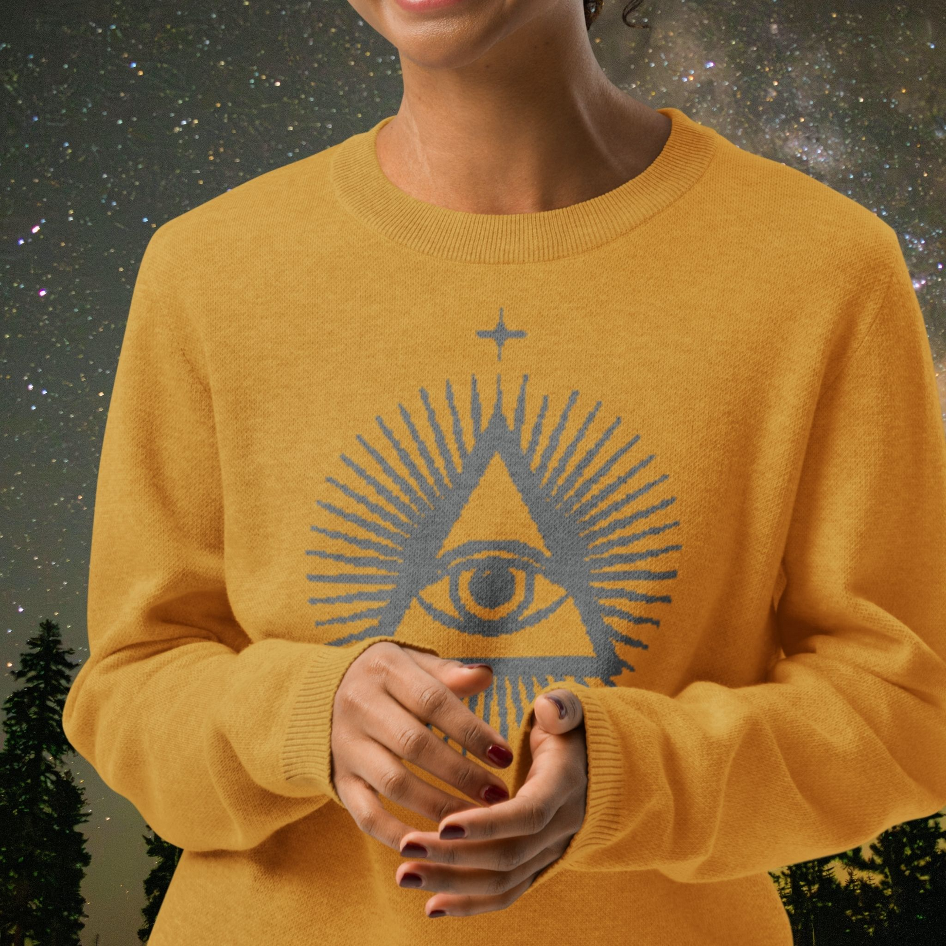 Person wearing a mustard yellow Stellarwear sweater with a geometric design against a starry sky background