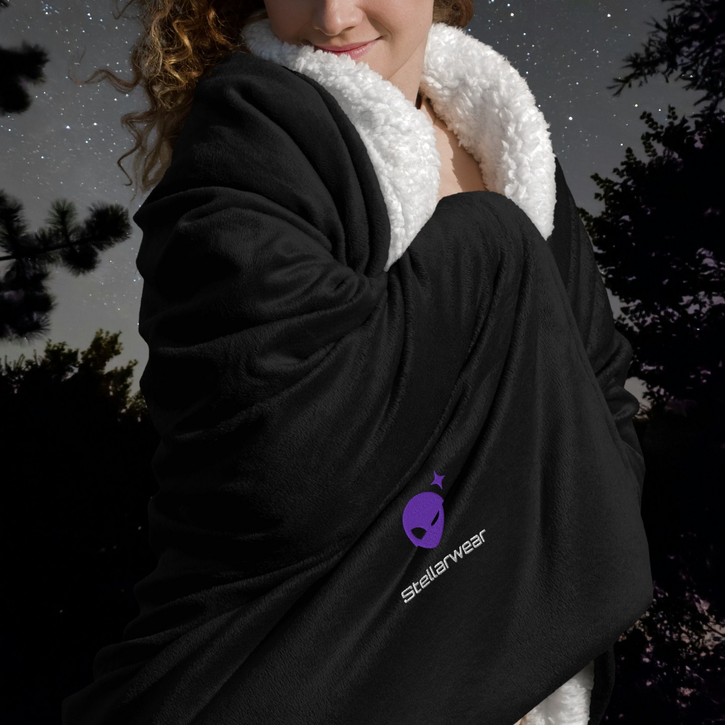 Person wearing a black jacket with a Stellarwear alien logo against a dark background