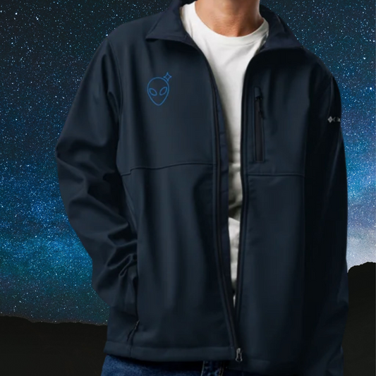 Person wearing a Stellarwear dark blue jacket with alien embroidery against a starry night sky background.