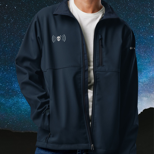 Person wearing a navy Stellarwear jacket with an alien logo against a starry night sky background