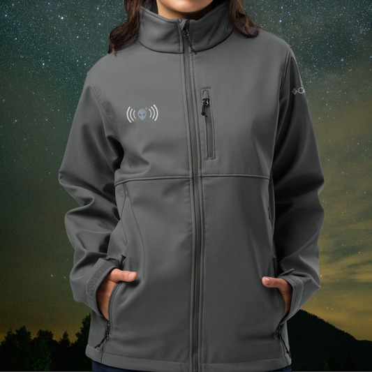 Person wearing a gray Stellarwear jacket with an alien logo on a starry night background