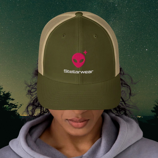 Person wearing a Stellarwear green cap with 'Stellarwear' alien logo against a night sky