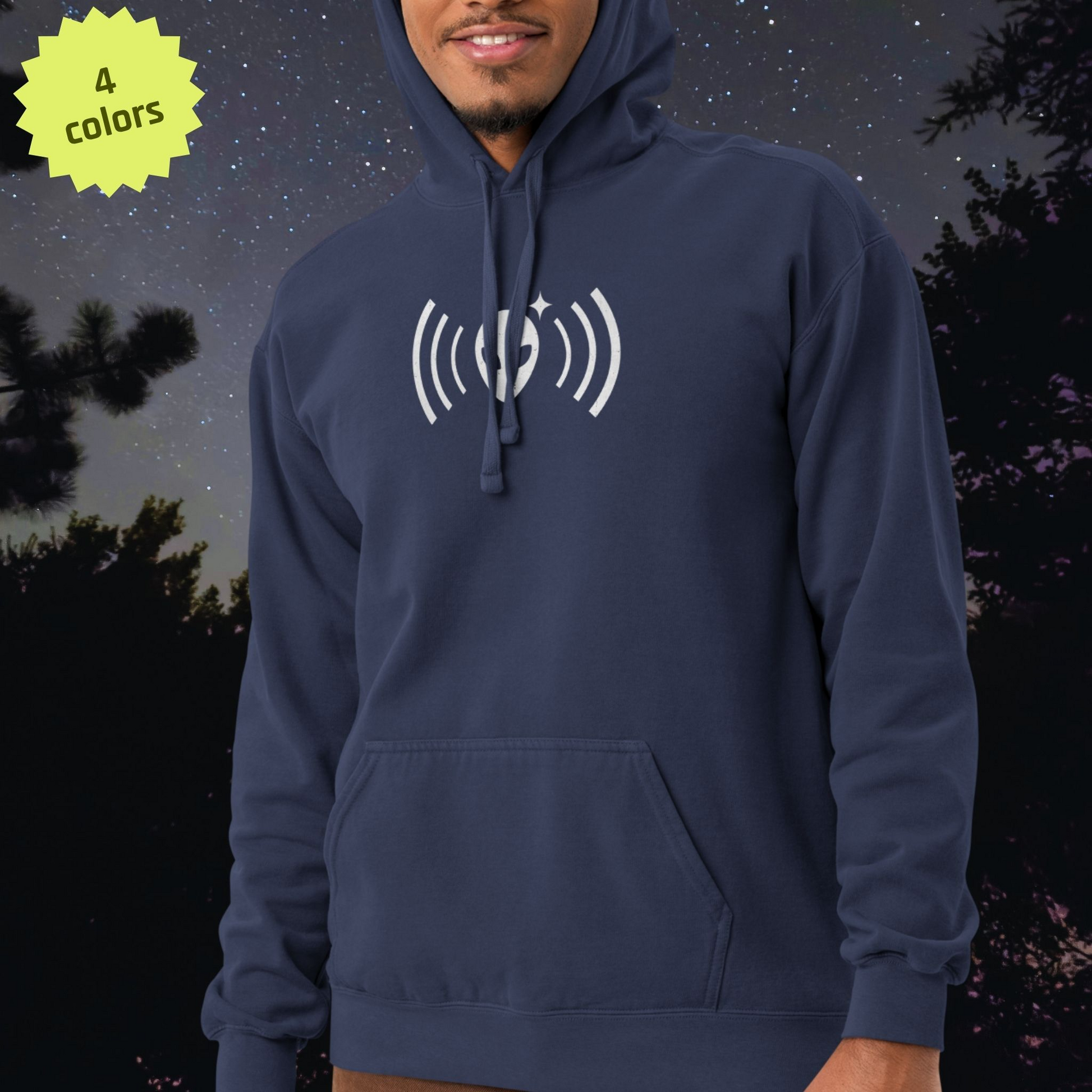 Person wearing a navy blue Stellarwear hoodie with a white alien logo against a night sky background