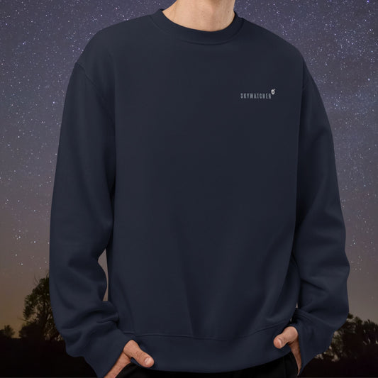 Stellarwear navy blue sweatshirt with "Skywatcher" embroidered on the chest against a starry night sky background