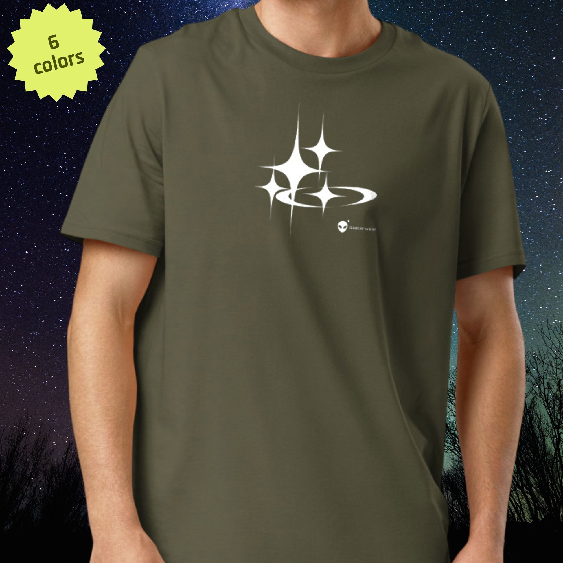 Person wearing a green Stellarwear t-shirt with a white alien and stars against a starry night sky background
