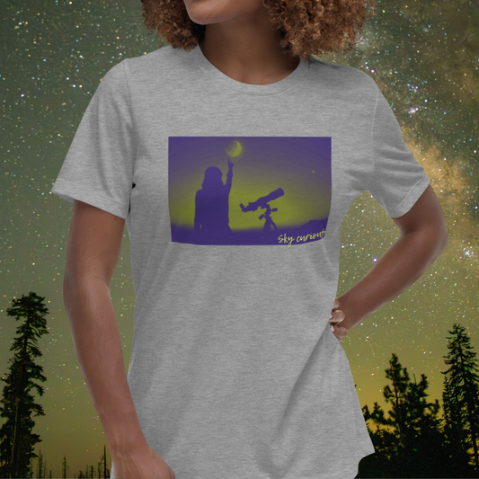 Person wearing a Stellarwear t-shirt with a graphic of a person holding a telescope against a starry night sky.
