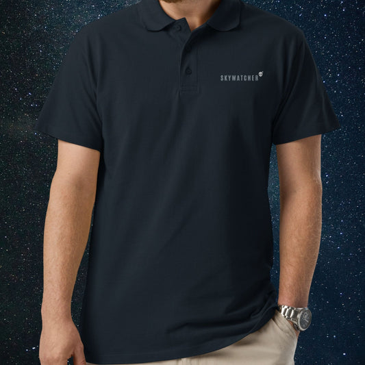 Person wearing a Stellarwear navy polo shirt with 'SKYWATCHER' logo against a starry night sky background