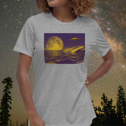 Person wearing a gray Stellarwear t-shirt with a whale, UFO and moon graphic, set against a starry night sky with trees.